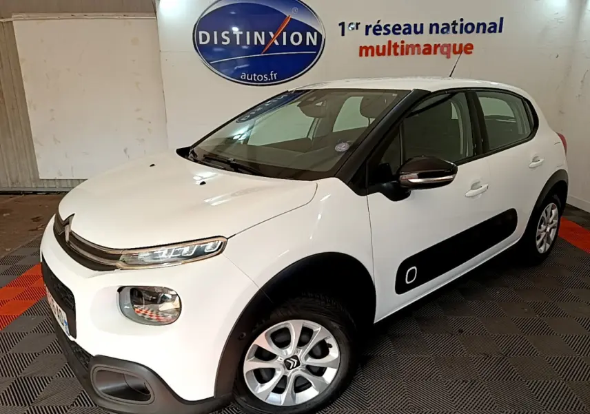 Citroën C3 blanche vue 3/4 avant droit avec protections latérales noires et jantes alliage.