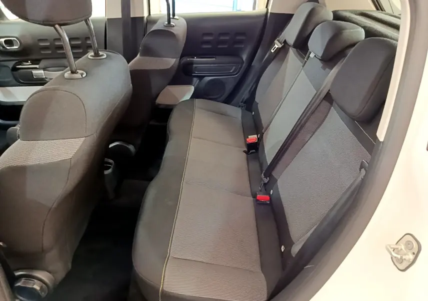 Vue intérieure côté droit montrant la banquette arrière grise et noire d'une Citroën C3 blanche de 2019.