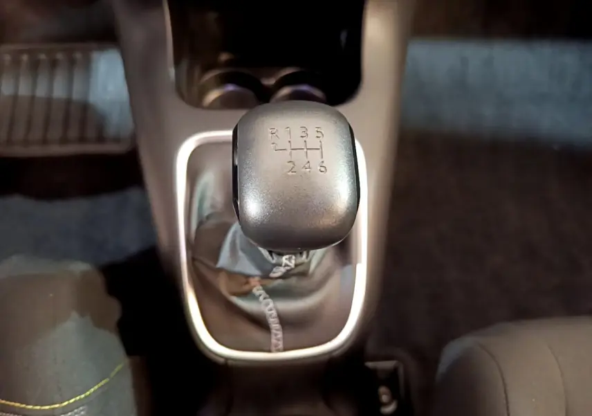 Le levier de vitesses manuel gris de la Citroën C3 blanche, vu en gros plan depuis l'intérieur.