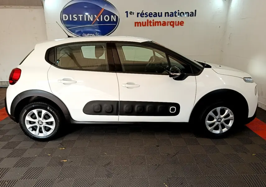 Profil côté gauche d'une Citroën C3 blanche de 2019 avec protections latérales noires et jantes alliage.