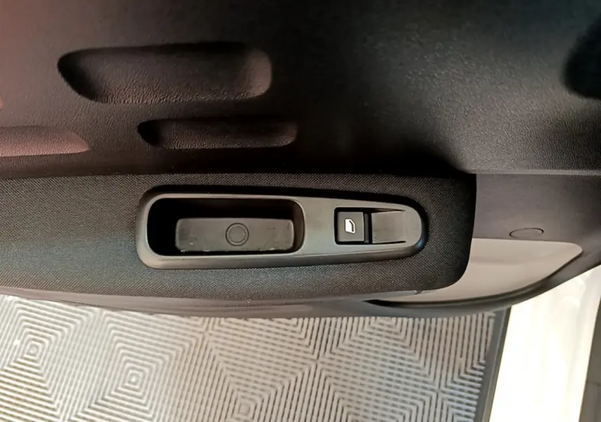 Poignée intérieure noire de la porte côté droit d'une Citroën C3 blanche, avec bouton de verrouillage.