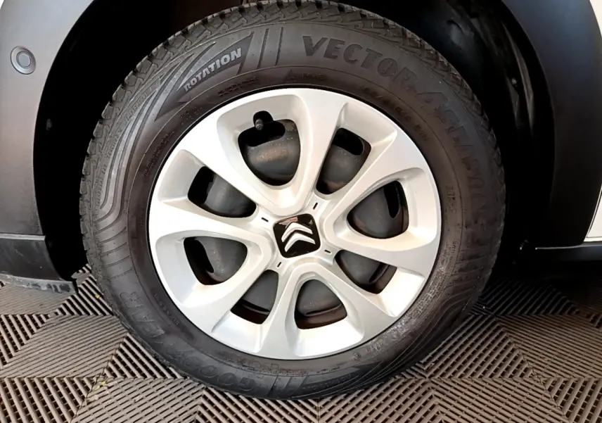Gros plan sur la roue avant droite de la Citroën C3 blanche, mettant en valeur la jante acier et le pneu Goodyear.
