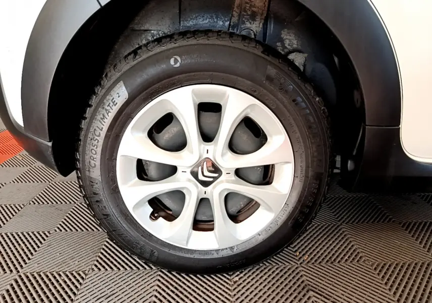 Gros plan sur la roue avant gauche blanche d'une Citroën C3 2019, avec jante alliage et pneu Michelin.