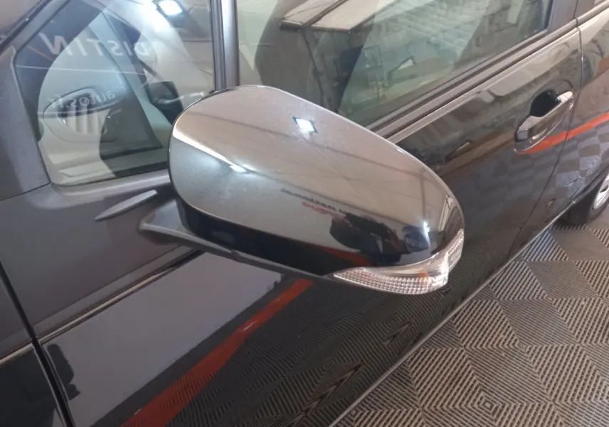 Rétroviseur droit noir brillant avec clignotant intégré sur Toyota Yaris 1.5 Hybrid France Business vue de côté droit.