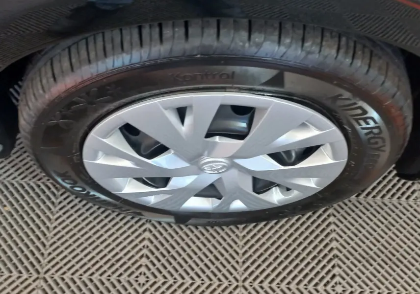 Gros plan sur la roue avant droite de la Toyota Yaris noire, avec jante argentée et pneu Hankook Kinergy Eco.