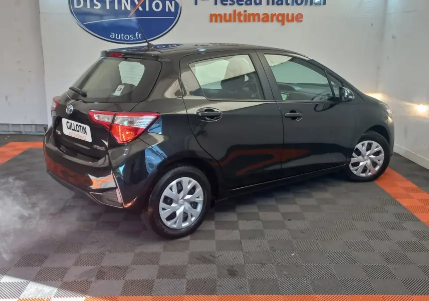 Toyota Yaris noire vue en 3/4 arrière côté droit, avec feux arrière et jantes acier visibles.