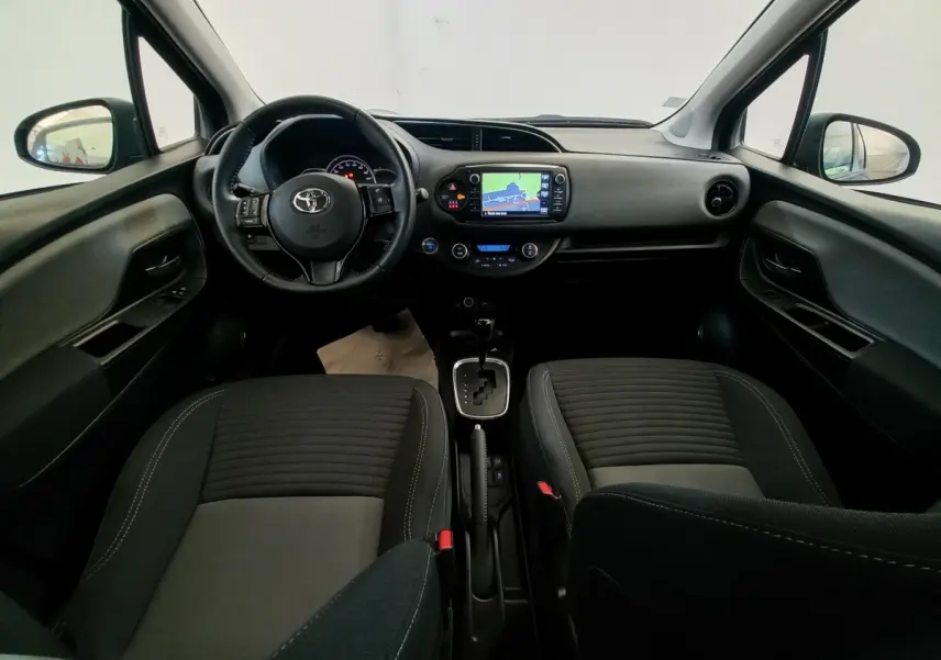 Vue intérieure avant de la Toyota Yaris noire 2018, montrant le tableau de bord avec écran tactile et volant multifonctions cuir.