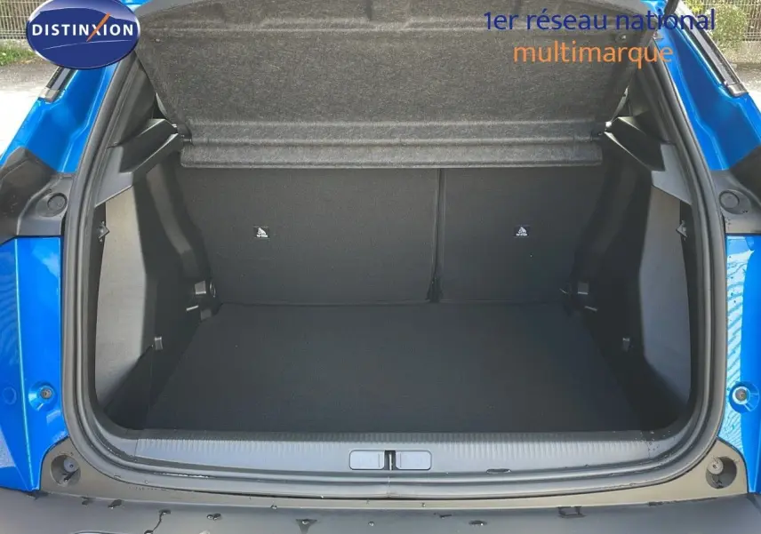 Coffre ouvert vu de l'arrière d'une Peugeot 2008 1.2 PureTech 100ch bleu Vertigo Métal, montrant l'espace de chargement vide.