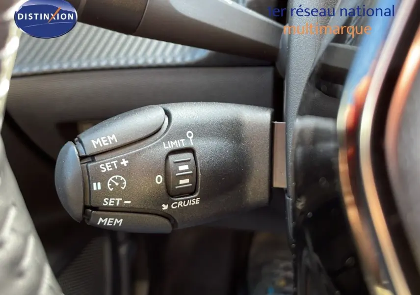 Gros plan sur la commande de régulateur de vitesse dans l'habitacle du Peugeot 2008 bleu Vertigo Metal.