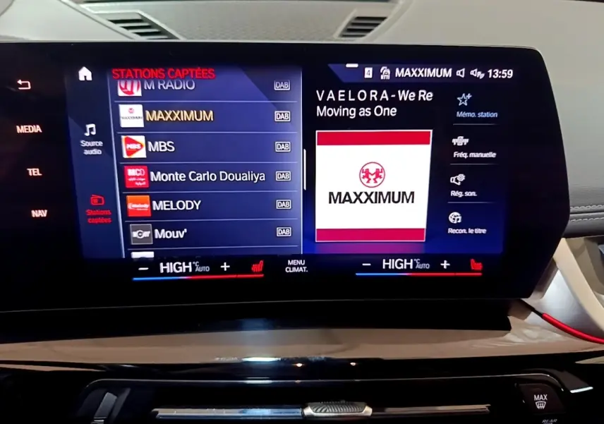 Écran tactile central du BMW X1 xDrive23i M Sport 2023 affichant la radio et commandes climatisation.