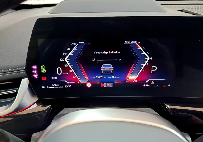 Vue rapprochée du tableau de bord numérique du BMW X1 xDrive23i M Sport gris clair, affichage multifonctions moderne.