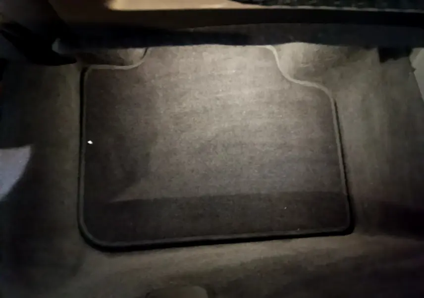 Tapis de sol noir vu de dessus à l'intérieur d'un BMW X1 xDrive23i M Sport gris clair, 2023.