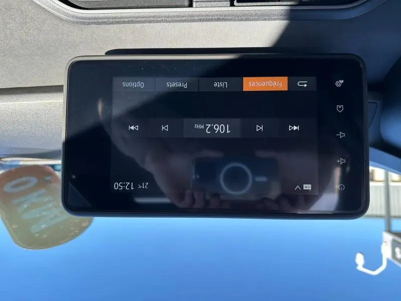 Écran tactile central du tableau de bord du Dacia Jogger blanc, affichant une radio FM à 106,2 MHz.