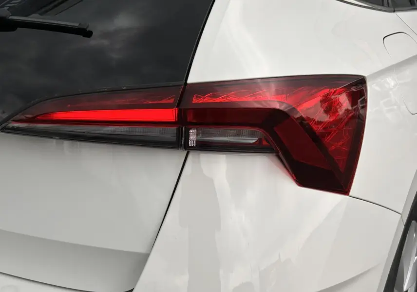 Gros plan sur le feu arrière droit d'une Skoda Scala 2025 blanc Candy avec lunette arrière surteintée.