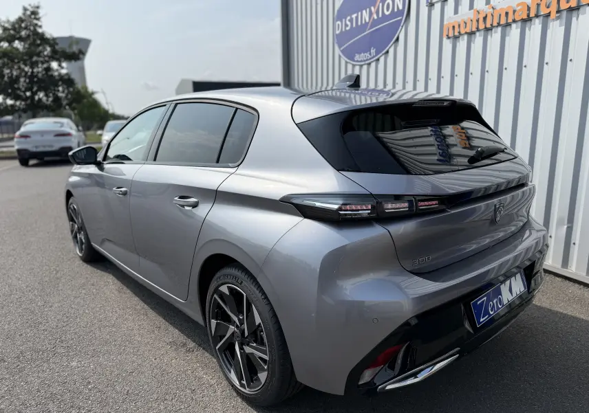 Peugeot 308 gris Artense vue 3/4 arrière droit, avec feux arrière LED et jantes alliage bicolores.