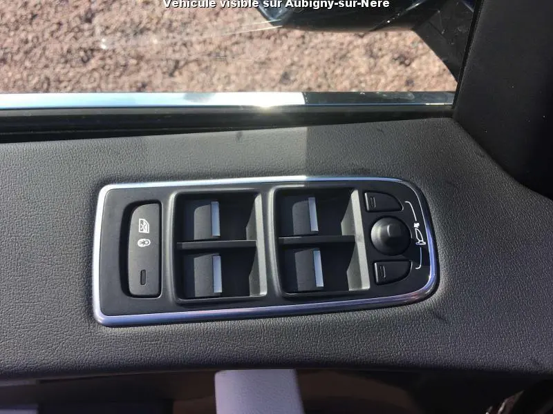 Panneau de commandes des vitres et rétroviseurs côté conducteur dans une Jaguar F-PACE noire de 2018.