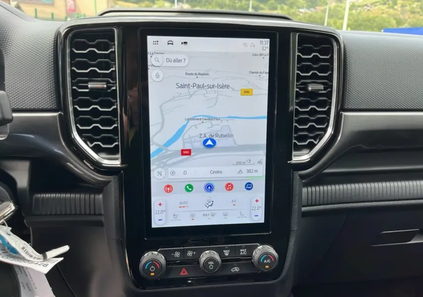 Écran tactile central du Ford Ranger 2025 gris carbone, affichant la navigation avec commandes climatisation en dessous.