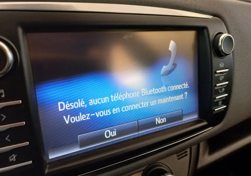 Écran tactile central de la Toyota Yaris 2019 affichant un message Bluetooth, vue rapprochée de l'intérieur noir.