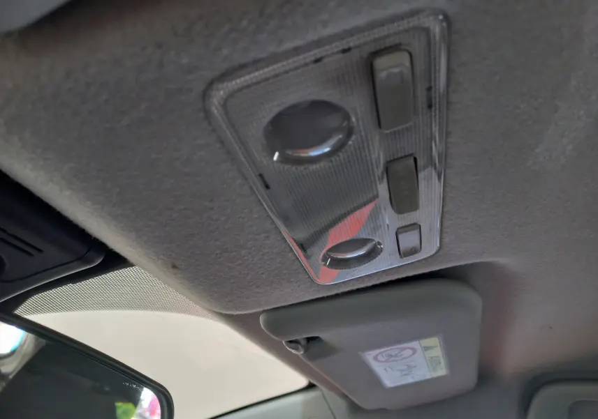Plafonnier intérieur et pare-soleil côté conducteur de la Toyota Yaris blanche, version hybride 2019.