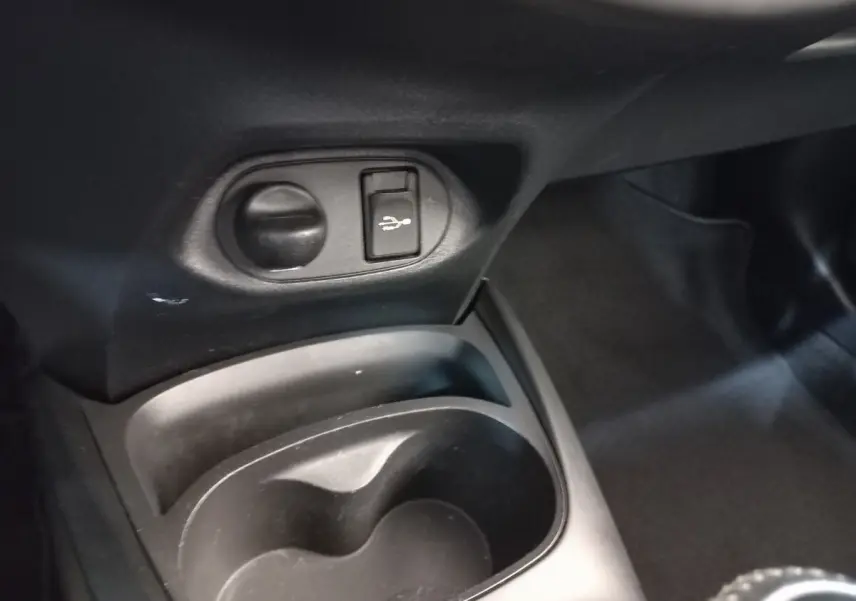 Gros plan sur la console centrale noire de la Toyota Yaris hybride 2019 montrant prise USB et porte-gobelet.