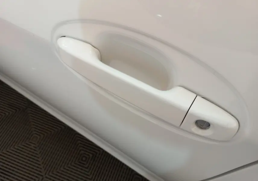 Poignée de porte blanche côté gauche de la Toyota Yaris 1.5 VVT-I HYBRID France Business 2019 vue en gros plan.