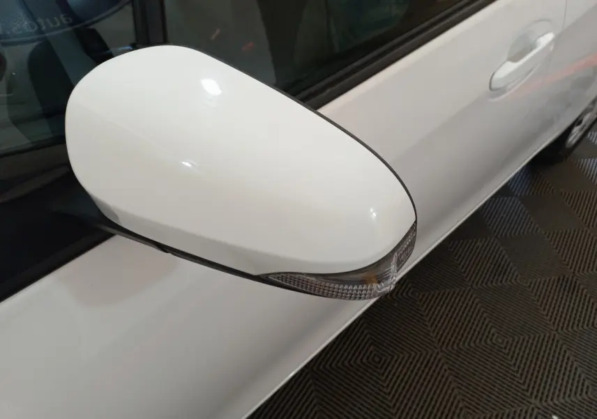 Rétroviseur côté gauche blanc de la Toyota Yaris hybride 2019, avec clignotant intégré, vue rapprochée sur porte.