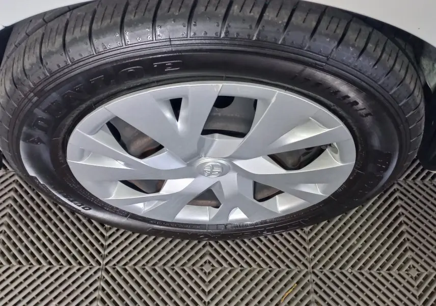 Gros plan sur la roue avant droite de la Toyota Yaris blanche avec jante en alliage et pneu Dunlop.