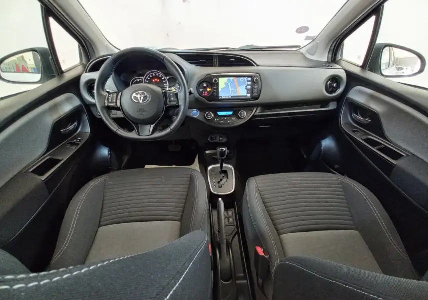 Vue intérieure avant de la Toyota Yaris hybride 2019, montrant le tableau de bord avec écran tactile et volant multifonctions.