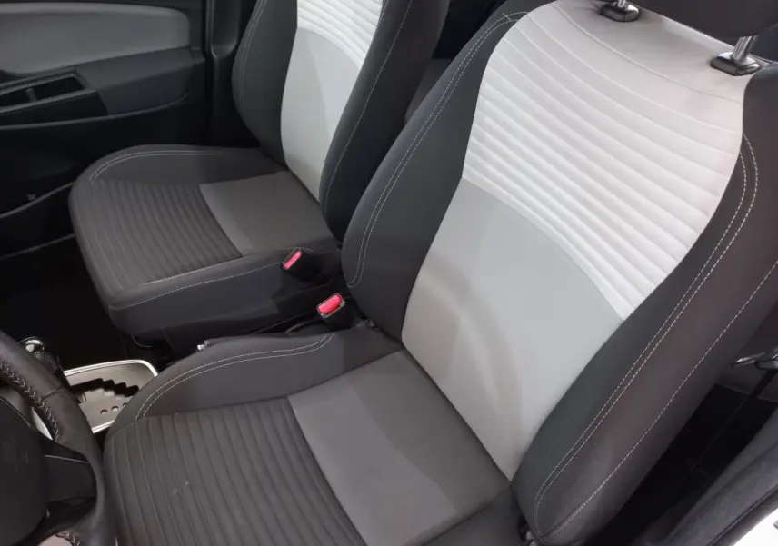 Gros plan sur les sièges avant gris clair et foncé de la Toyota Yaris 1.5 Hybrid, intérieur moderne et épuré.