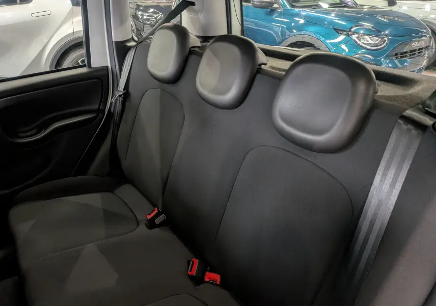 Vue intérieure sur la banquette arrière noire de la Fiat Panda 1.0 Hybrid 2025, avec appuie-têtes et ceintures visibles.