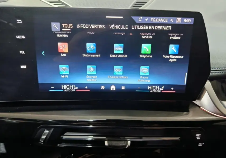 Écran tactile central du tableau de bord de la BMW X1 xDrive25e blanc, affichant le menu des réglages.