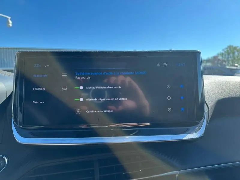 Écran tactile central du Peugeot 2008 Hybrid 2025 affichant les aides à la conduite dans un intérieur lumineux.