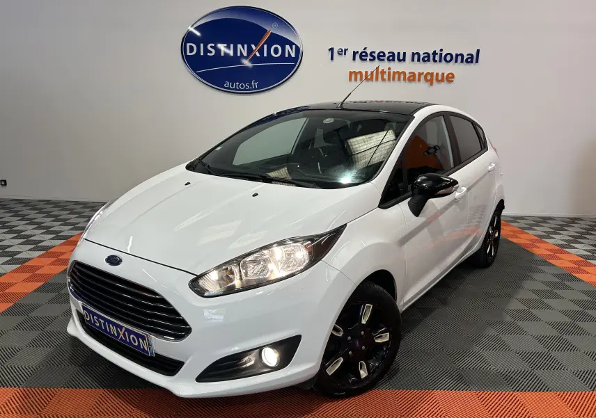 Ford Fiesta EcoBoost blanche vue en 3/4 avant droit, avec jantes noires et toit panoramique noir.