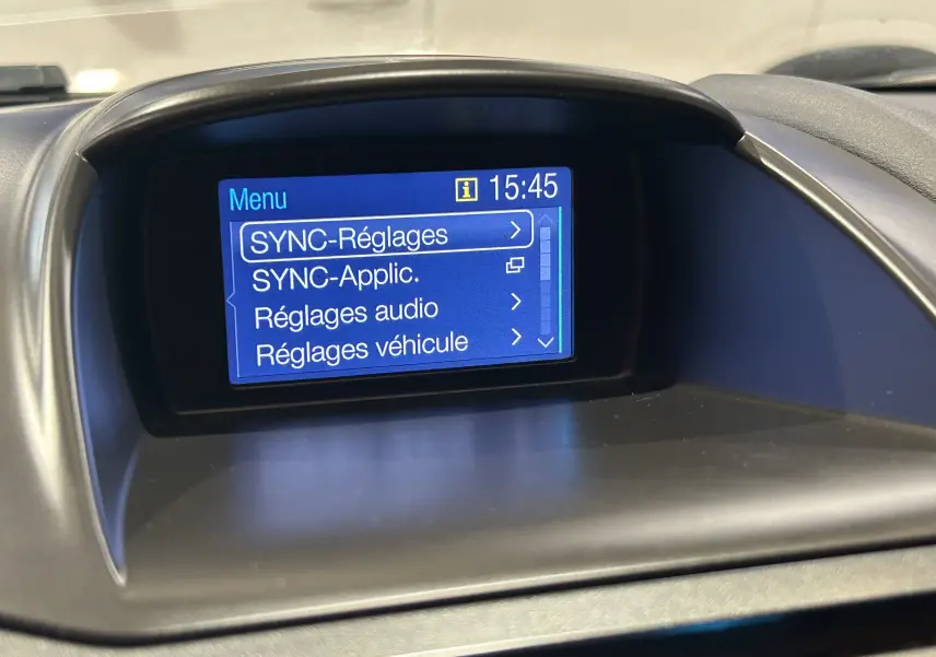 Écran central de la Ford Fiesta blanc 2015 affichant le menu SYNC avec réglages audio et véhicule à 15h45.