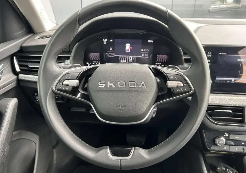 Vue frontale du volant cuir multifonctions SKODA SCALA 2025 avec tableau de bord digital et écran tactile à droite.