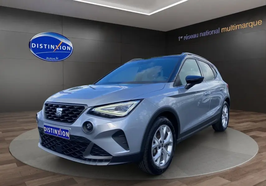 SEAT Arona gris silver avec toit noir en 3/4 avant droit, jantes alu 17 pouces et feux LED allumés.