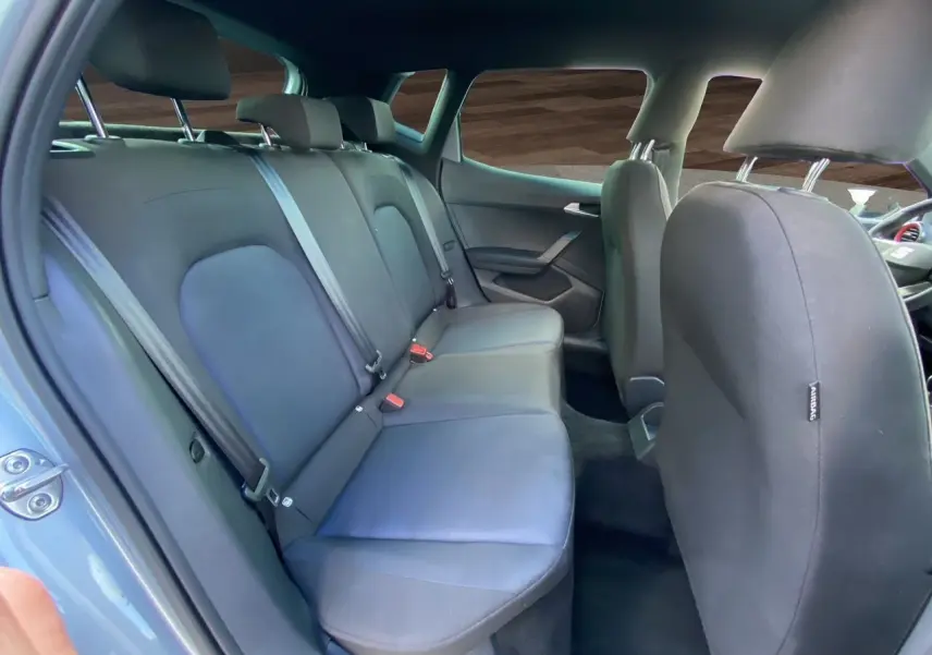 Vue intérieure arrière de la SEAT Arona 2024 avec sièges tissu noir et ceintures de sécurité visibles.
