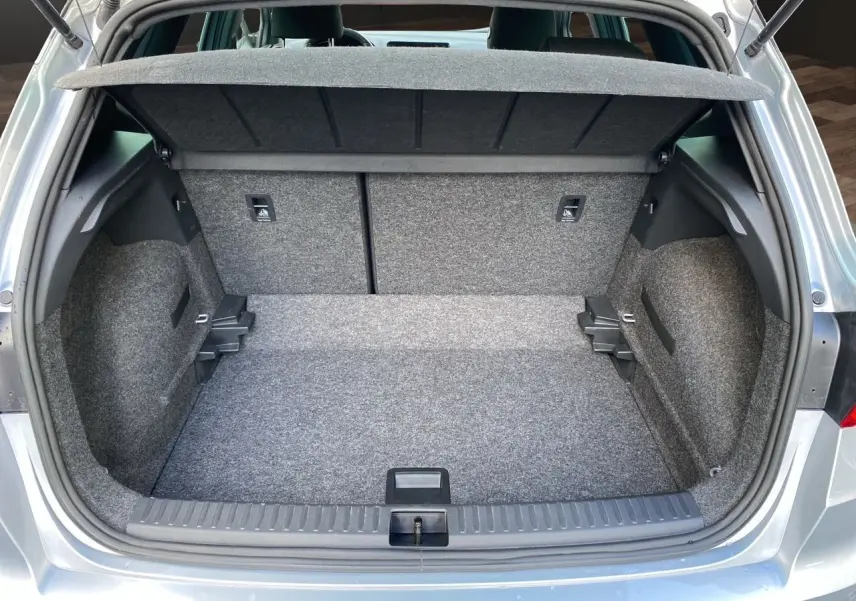 Coffre ouvert d'un SEAT Arona gris silver, vue arrière montrant l'espace de chargement et la moquette intérieure.