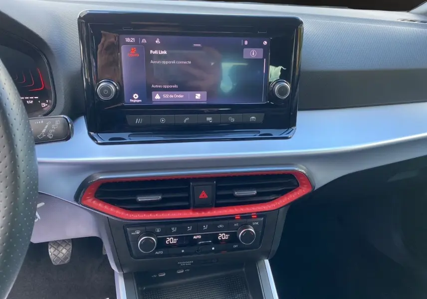 Vue rapprochée du tableau de bord gris et noir du SEAT Arona 2024, avec écran tactile et commandes de climatisation.