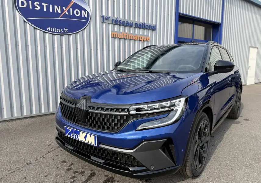 Renault Austral 2025 bleu Iron avec toit noir, vue 3/4 avant mettant en valeur sa calandre noire et ses phares LED.