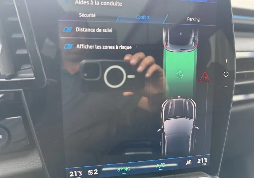 Vue du tableau de bord du Renault Austral 2025 avec écran tactile affichant les aides à la conduite et la climatisation réglée à 21°C.