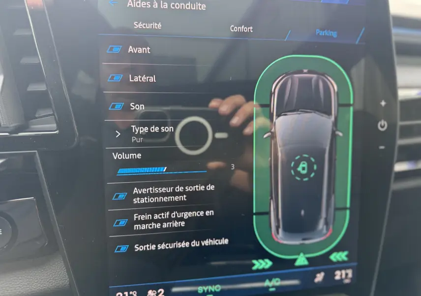 Écran tactile du tableau de bord du Renault Austral 2025 montrant les aides à la conduite et la vue top-down du véhicule bleu iron toit noir.