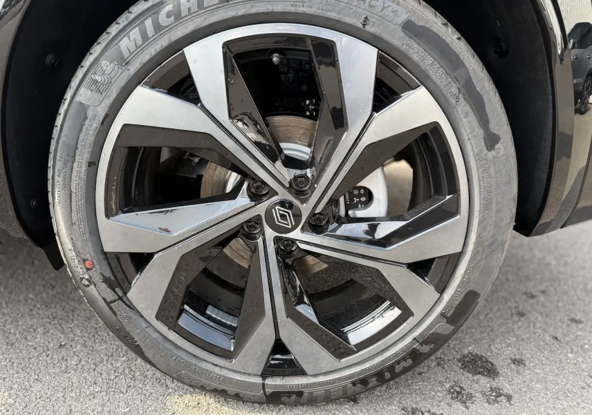 Gros plan sur la jante alliage bicolore noire et argentée du Renault Austral 2025 bleu iron toit noir.