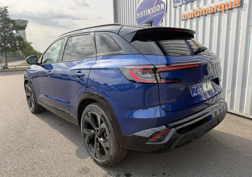 Vue 3/4 arrière droite du Renault Austral 2025 bleu Iron avec toit noir, feux LED et jantes noires distinctives.