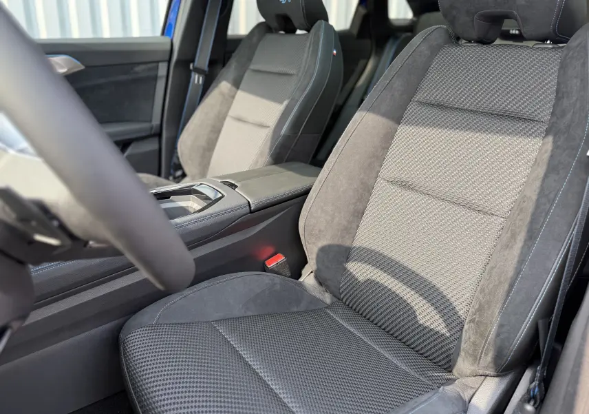Gros plan sur les sièges avant en tissu et alcantara gris avec surpiqûres bleues du Renault Austral 2025 finition Esprit Alpine.