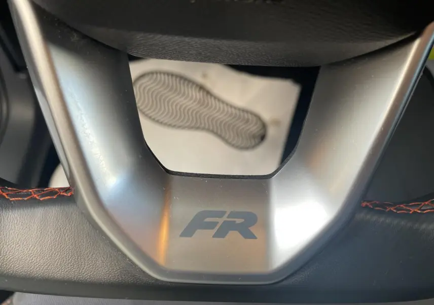 Gros plan sur le volant cuir noir avec logo FR et surpiqûres rouges du SEAT Arona 2024 GRS.