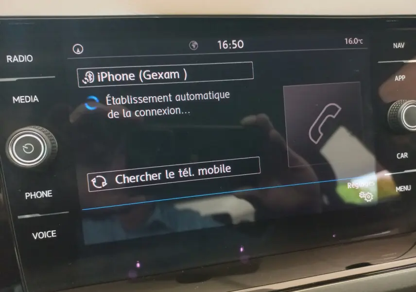 Écran tactile central de la Volkswagen Polo noire 2020 affichant la connexion Bluetooth d'un iPhone.