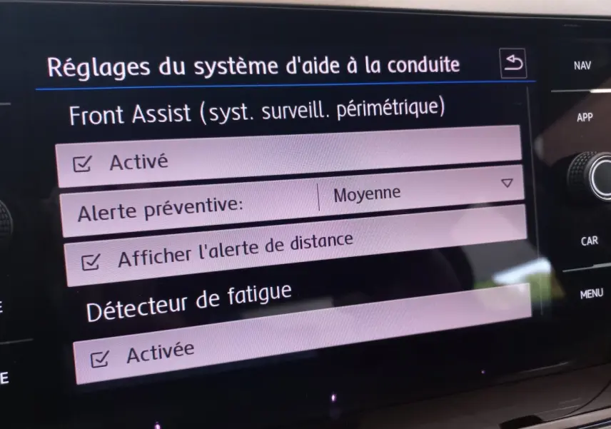 Écran tactile intérieur de la Volkswagen Polo noire montrant les réglages d'aide à la conduite et détecteur de fatigue activés.