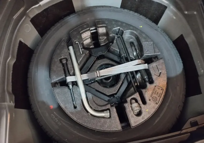 Gros plan sur la roue de secours et les outils de bord dans le coffre d'une Volkswagen Polo noire 2020.