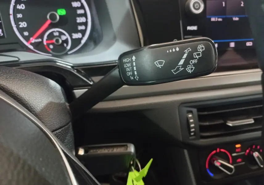 Gros plan sur la commande d’essuie-glace à gauche du volant dans l’habitacle noir d’une Volkswagen Polo 2020.